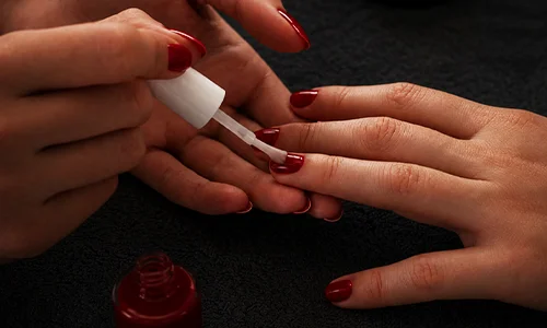 Nail technician applying powder coating